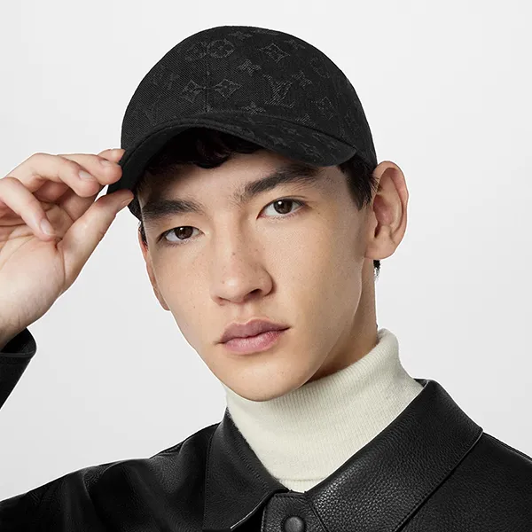 Model wearing a black Louis Vuitton Monogram Essential cap.