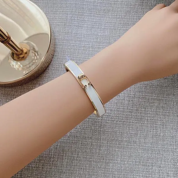 Vòng Đeo Tay Coach Signature Push Hinged Bangle F67480 Màu Trắng Vàng